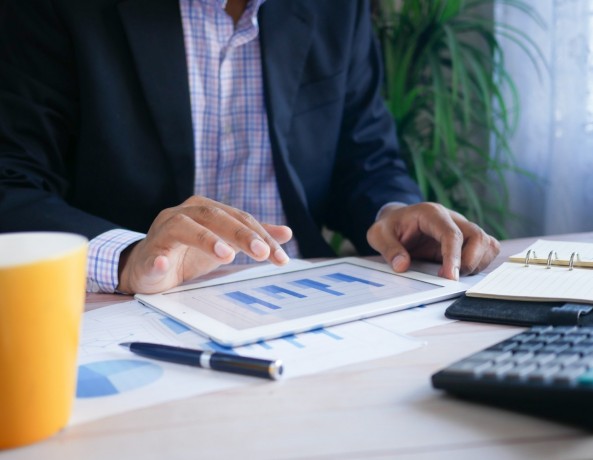 person in black suit jacket holding white tablet computer