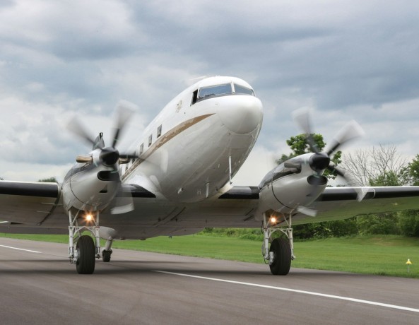 a small propeller plane on a runway with trees in the background