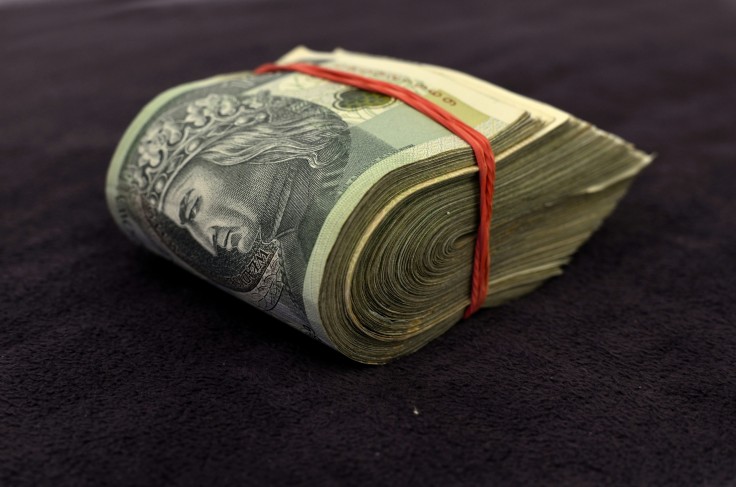 large folded stack of bills held with a red rubberband