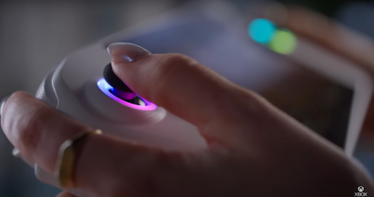 Hand gripping Xbox handheld joystick with glowing LED ring