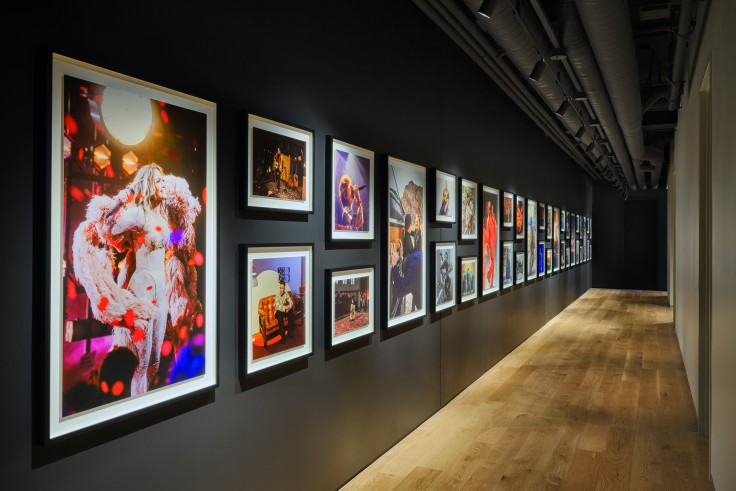 Framed artist photos line hallway at Apple Music Studio