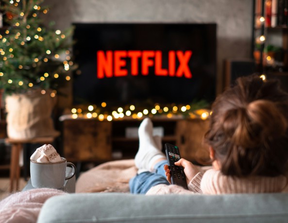Person Sitting on Couch Watching Netflix