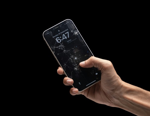 Person Holding Phone with Cracked Screen