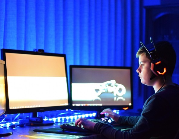 Man gaming with three monitors